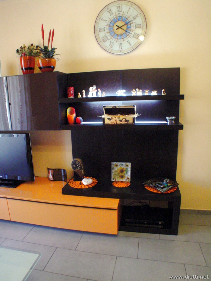 Il particolare sull'elemento panca in rovere moro e le mensole luminose montate su pannello boiserie.